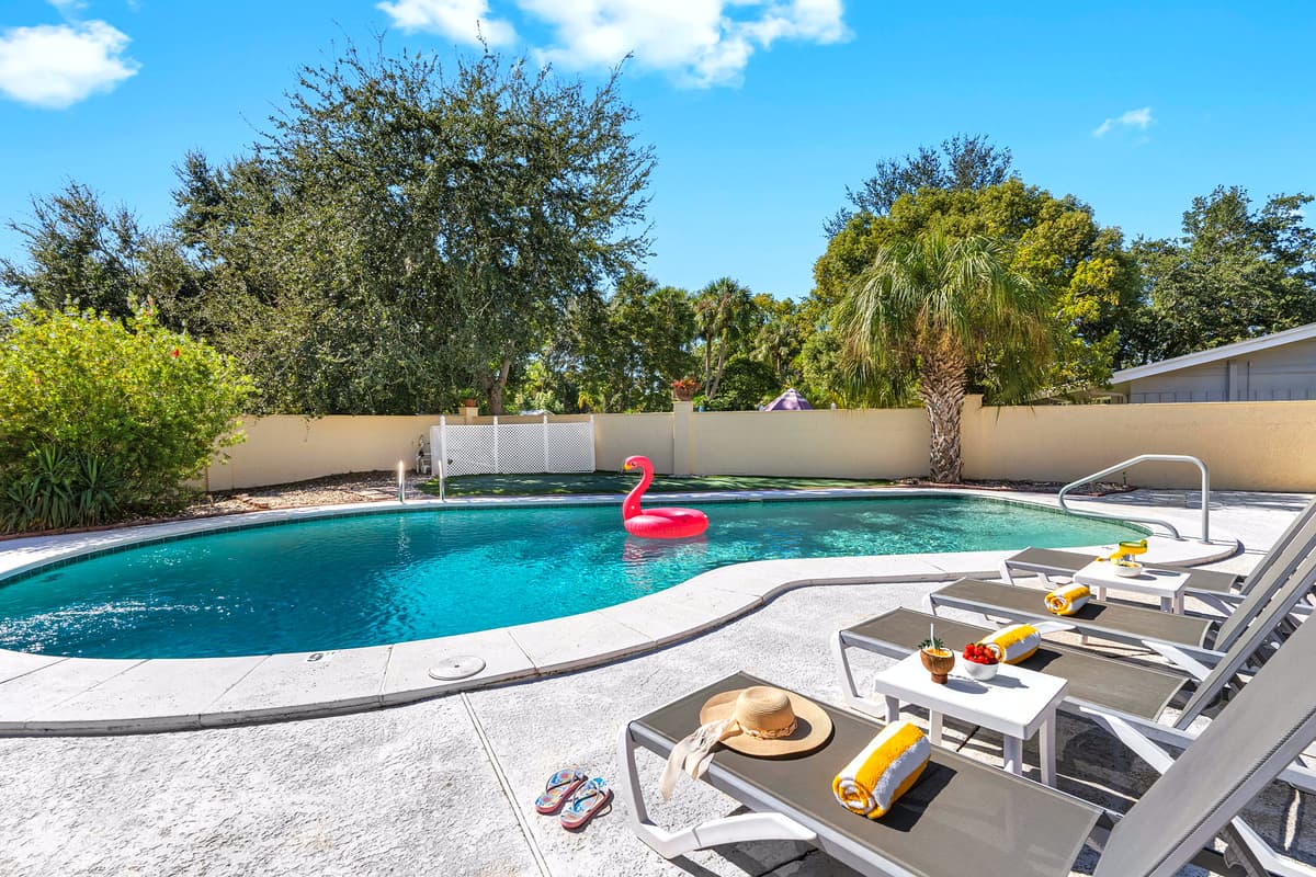 Unwind in this private backyard oasis featuring a sparkling pool, comfy loungers, and lush tropical landscaping — perfect for soaking up the Florida sunshine.