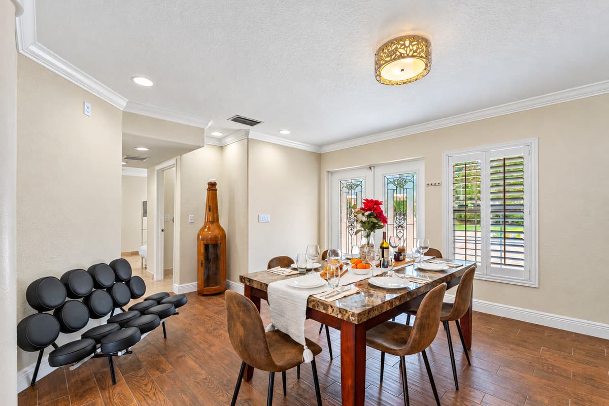 Set with a stone-look table, comfortable suede-style chairs, and tasteful place settings, this dining area is ready for memorable meals.