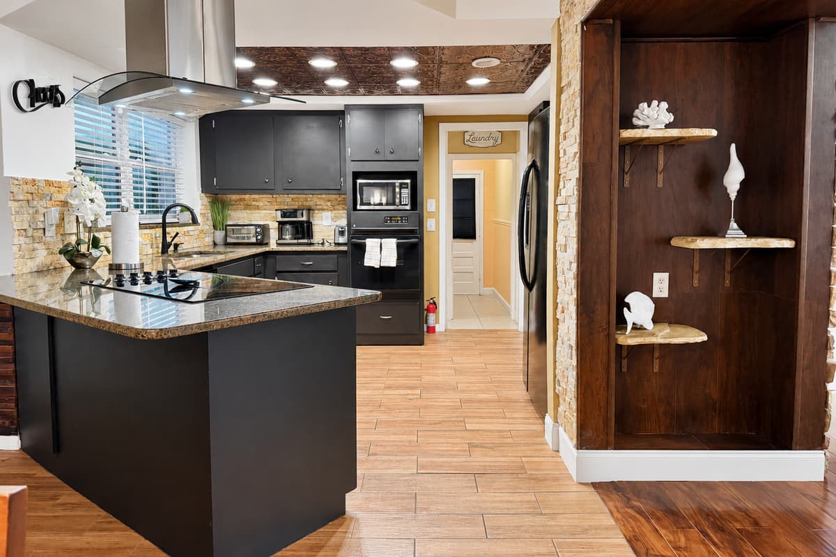 Simple yet elegant, this well-appointed kitchen combines modern appliances and rich wood tones with subtle backsplash details for a warm, welcoming feel.