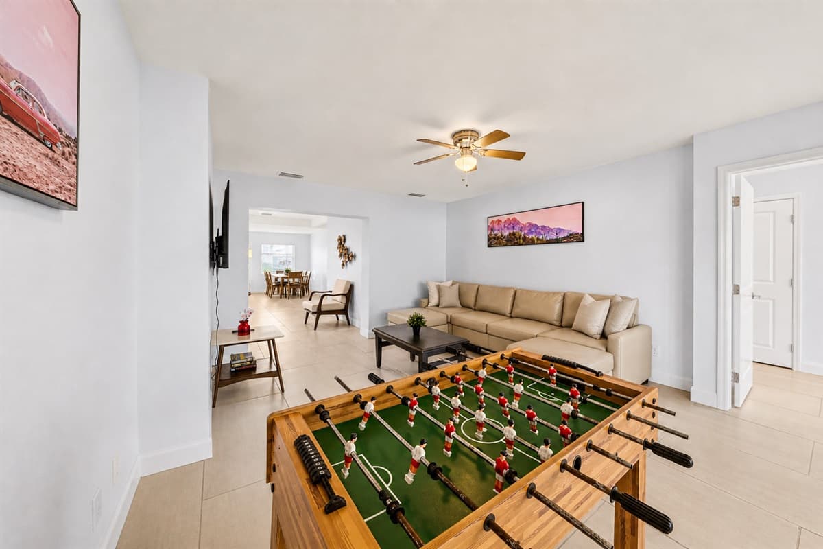 Game room area with foosball table and open access to the living and dining spaces.