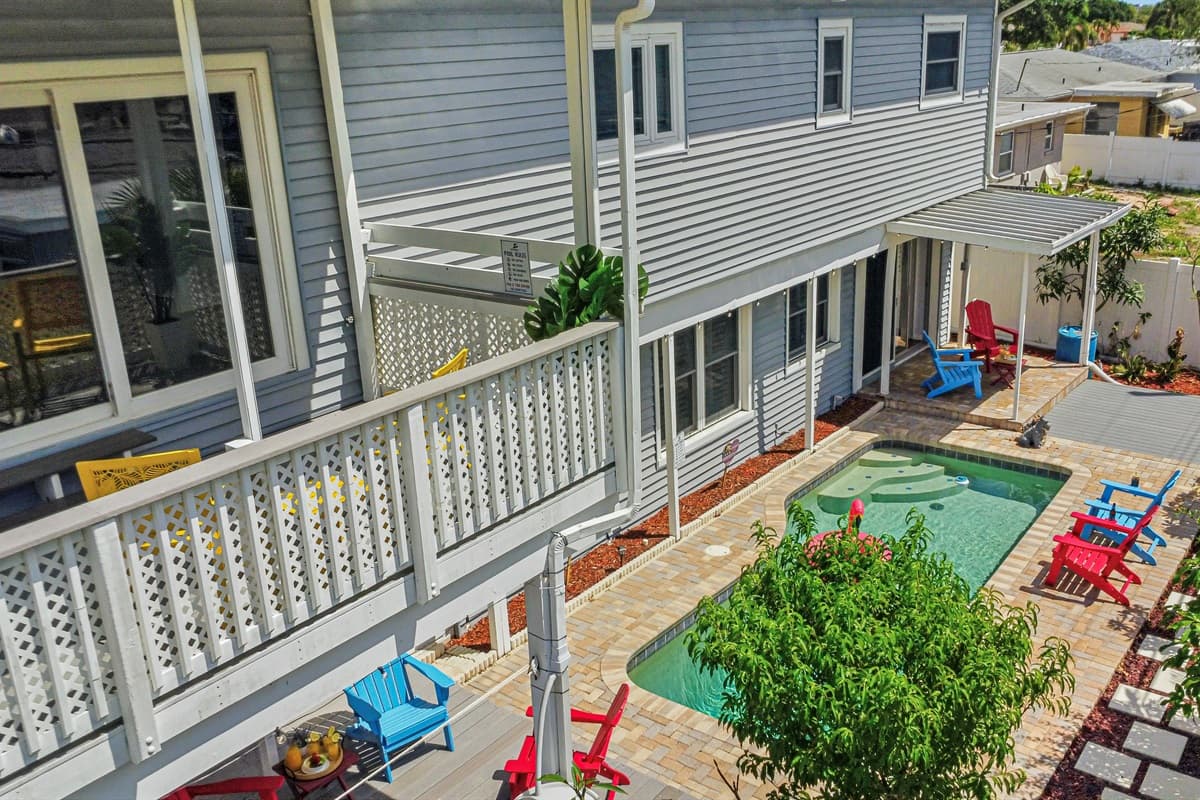Elevated view of the backyard showcasing the pool, seating areas, and home exterior—ideal for group gatherings 
