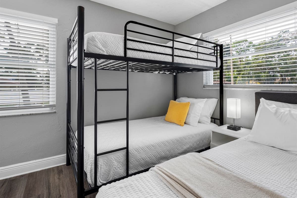 The playful vibe, modern bunk setup, and cheerful yellow accent pillows make this a hit with younger guests and teens alike.