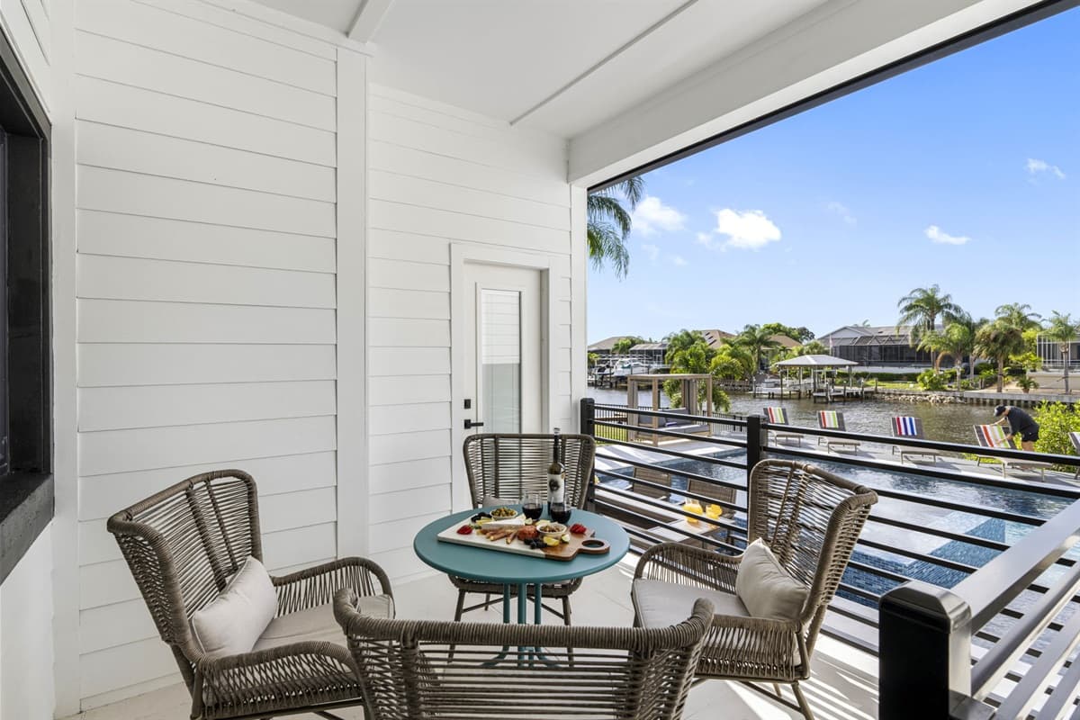 This balcony features a beautifully crafted round dining table, thoughtfully designed to accommodate up to five guests. The table features a polished surface that reflects sunlight, enhancing the overall ambiance of the space.