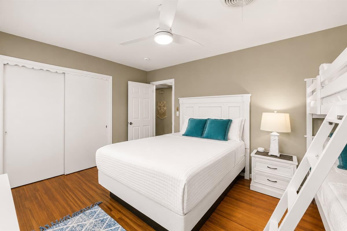 Cozy guest room with modern furnishings, ample closet space, and bunk beds perfect for families.