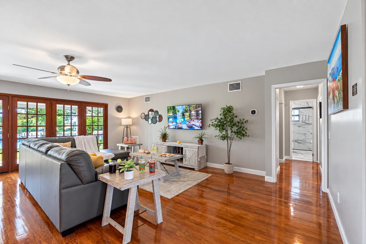 The abundance of glass doors allows sunlight to stream through, highlighting the rich wood floors and soft gray walls.