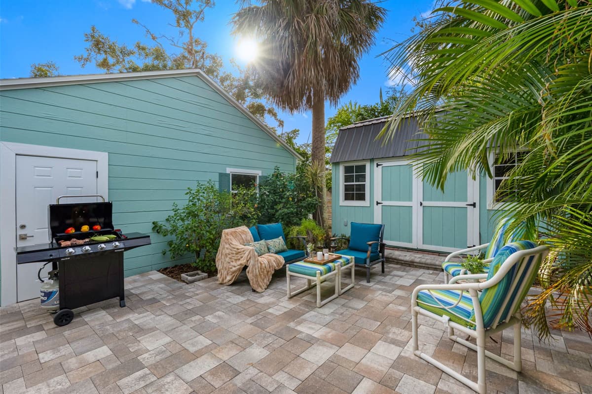 Relax in this inviting outdoor seating area surrounded by lush tropical landscaping and vibrant greenery.