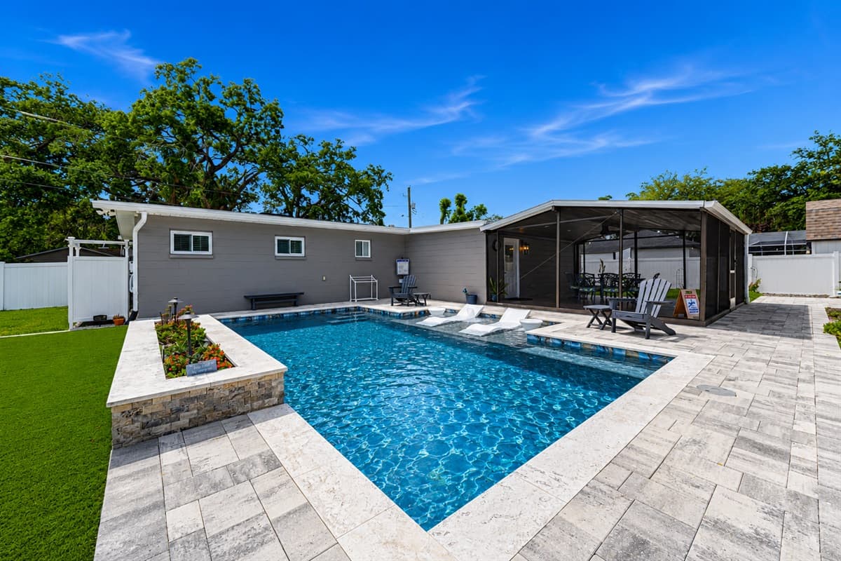 Bright backyard pool oasis featuring expansive patio space and plenty of room to relax under the Florida sun.