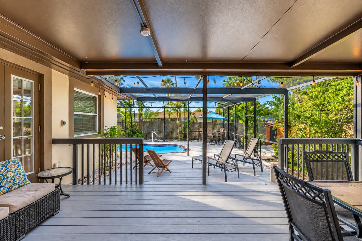 Spacious screened patio with cozy seating areas and relaxing poolside views.