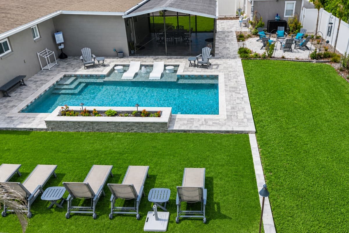 Elevated backyard perspective featuring resort-style pool amenities and expansive green space for outdoor enjoyment.