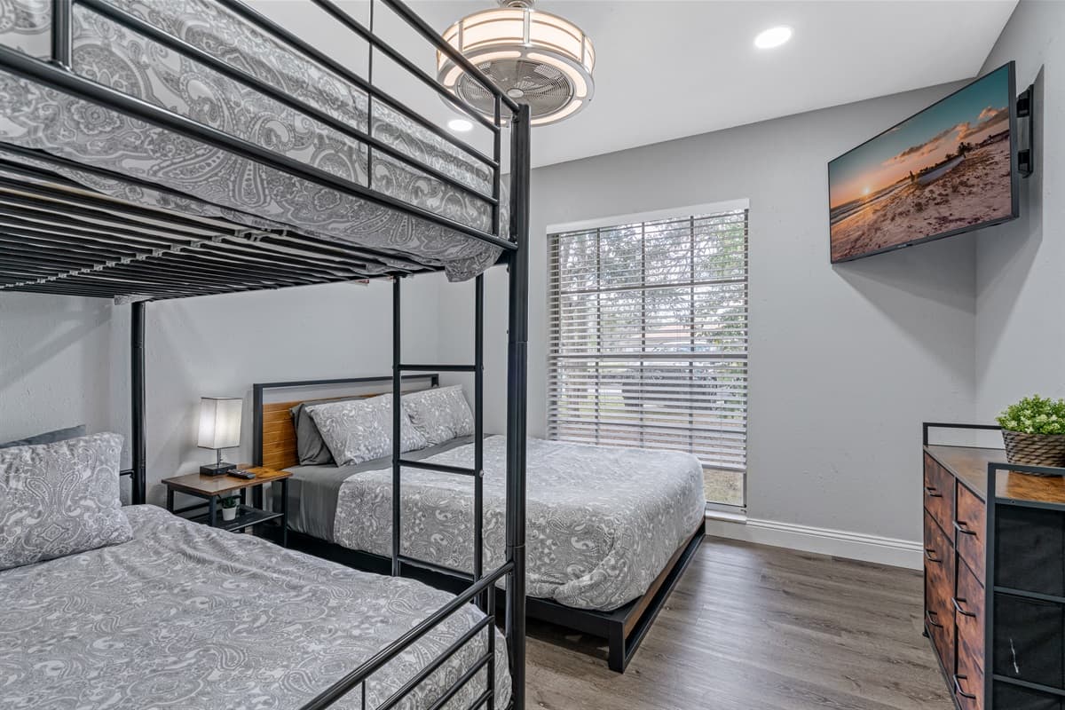 Beautiful bedroom with a bunkbed, queen sized bed, drawers for storage and smart TV. Ideal room for a family with kids or a group of friends. 