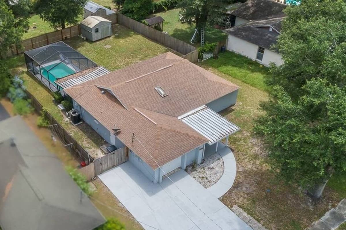 Aerial side profile of the property showcasing the beautiful fully fenced backyard, our immaculate heated pool and spacious driveway. If you are interested in this property, send us an inquiry as soon as possible!