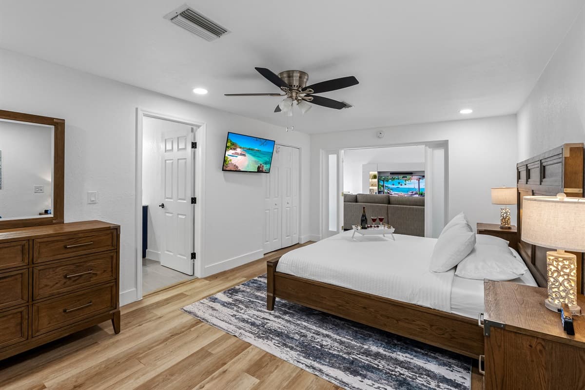 Wake up refreshed in this beautifully appointed master bedroom with rich wood finishes, calming tones, and a mounted Smart TV for lazy mornings.