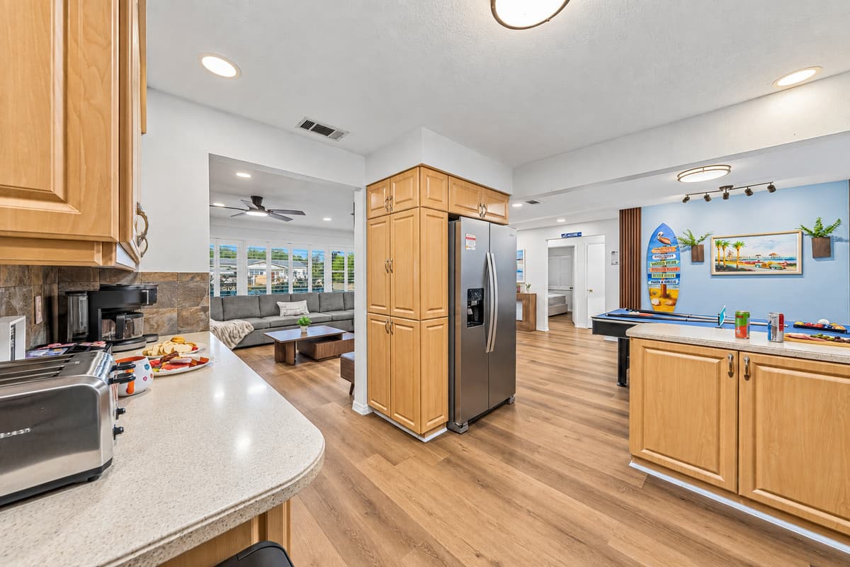 Open kitchen layout with bar seating and seamless flow into the living and game areas 