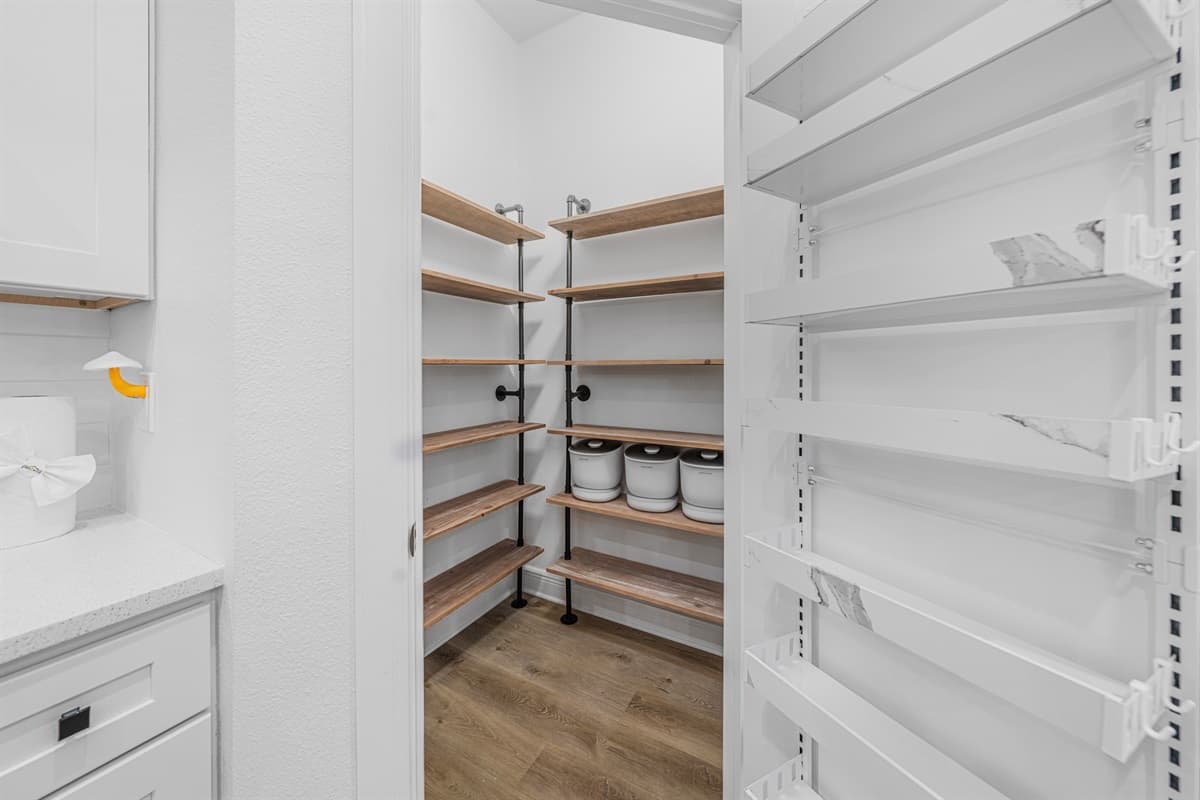 Walk-in pantry with generous shelving, perfect for storing groceries and essentials.