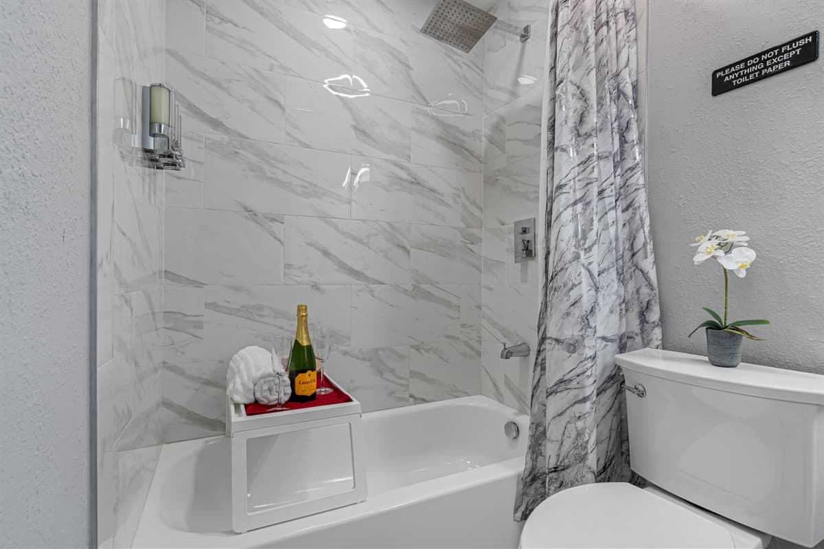 Stunning bathroom with bathtub, sink, toilet and walk in shower.  Enjoy a relaxing bath after a long day of travel from your home to your home away from home. If you like this property, send us a message now!