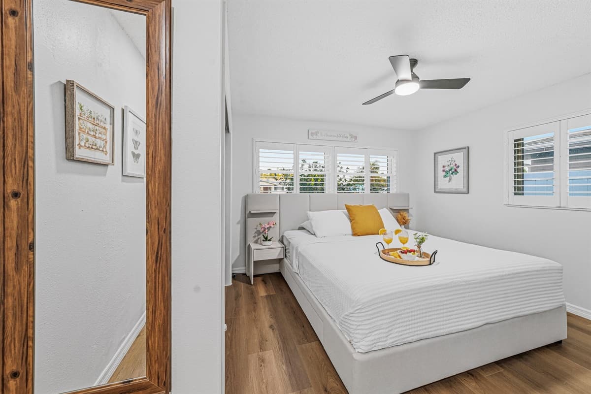 Bedroom view reflected through a full-length mirror, showcasing the clean and modern design 