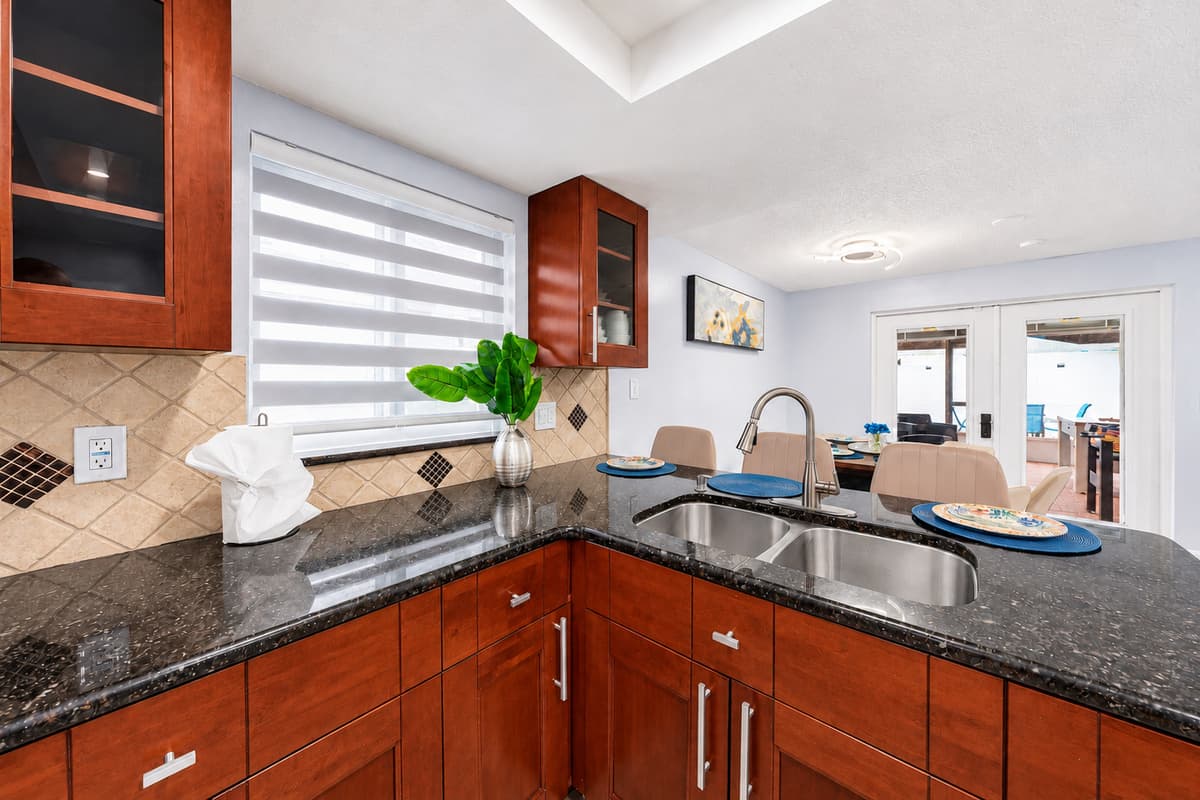 Modern kitchen featuring granite countertops, stainless steel appliances, and ample workspace for preparing meals during your stay.