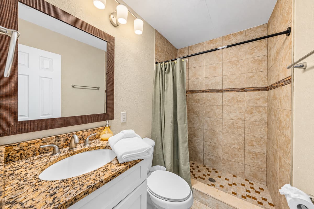 Stylish bathroom with tiled walk-in shower and modern finishes.