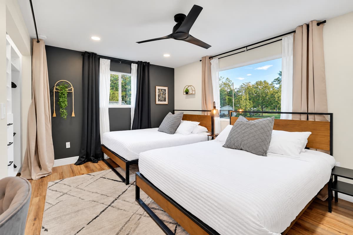 Two queen beds, so nobody sleeps on a sofa. Wide, bright room with a workspace and a window to the garden — built for four friends, two couples, or parents who want the kids in one place.