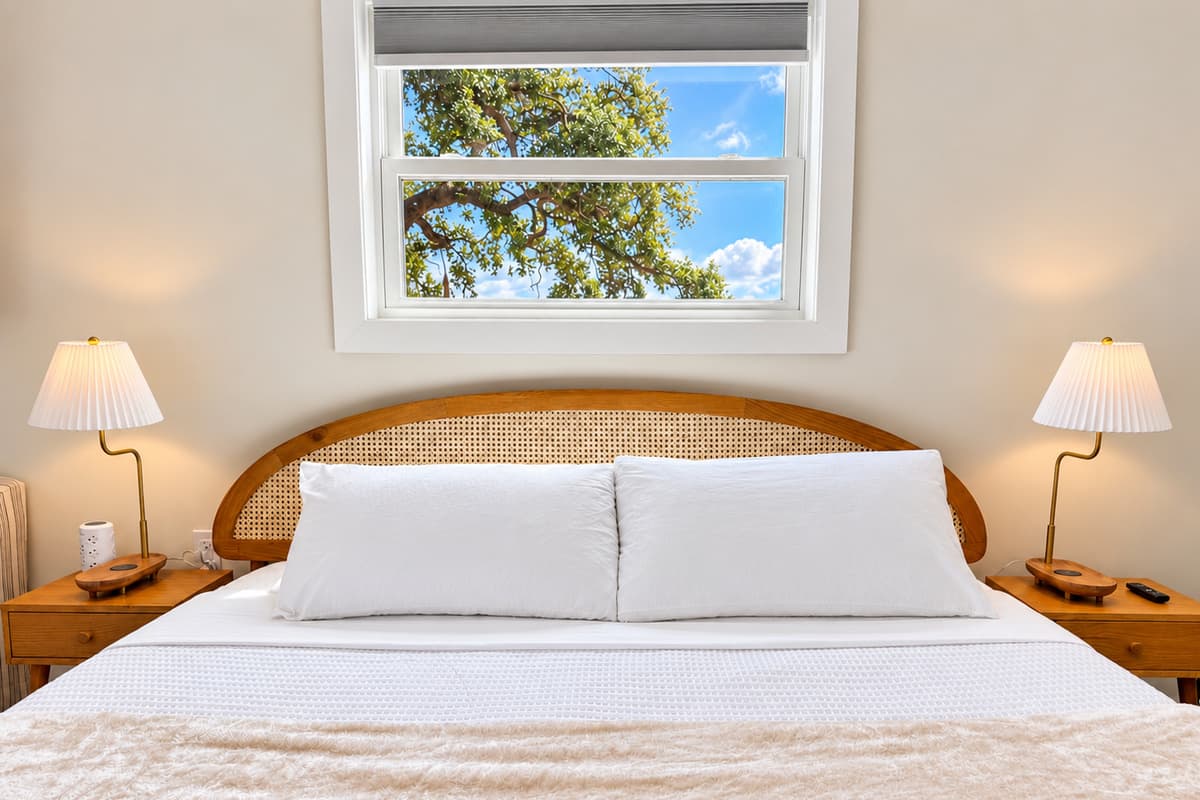 King bedroom with a woven wood headboard and coastal decor.