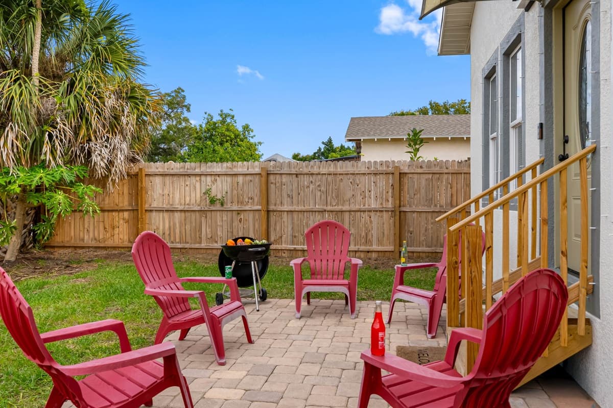 Enjoy the private backyard seating area featuring comfortable Adirondack chairs arranged on a paved patio—perfect for morning coffee, casual conversations, or evening relaxation.