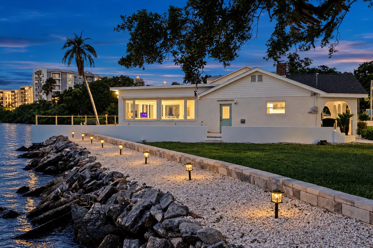 A lit path along the seawall. Landscape lights line the waterfront walkway and rock seawall. Take an evening stroll by the water before heading in for the night.