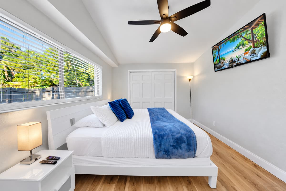 Fresh white linens, a bedside table for your phone and glasses, and a ceiling fan doing what Florida ceiling fans do best. This is the room where the beach day finally catches up with everyone who spent it outside.