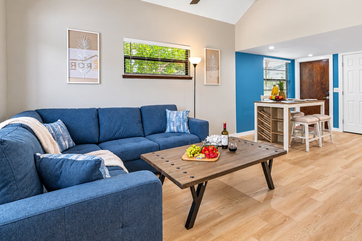 As you step into this inviting space, you're greeted by a captivating blue sofa that instantly catches your eye.