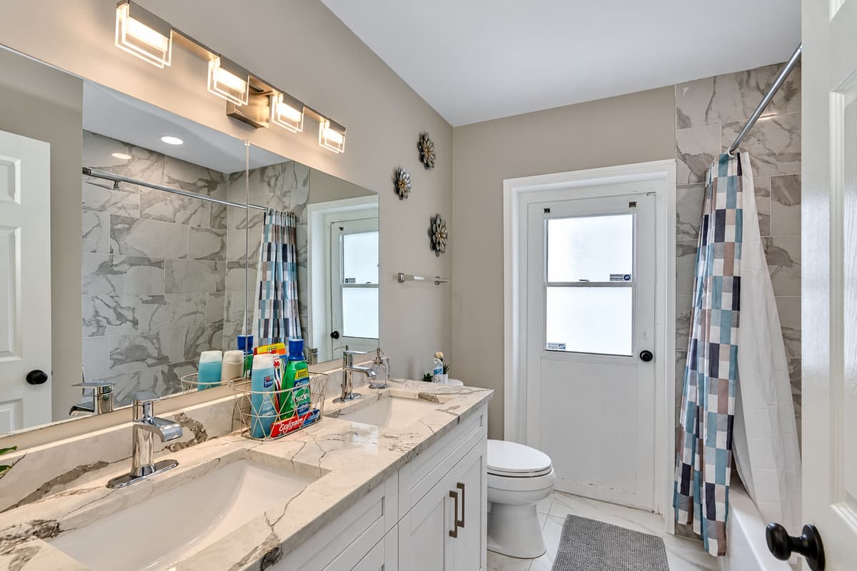 Beautiful bathroom equipped with his and hers sink, toilet, and shower. Enjoy a relaxing bath after a long day of travel from your home to your home away from home. If you think this property is for you, send us an inquiry right away!