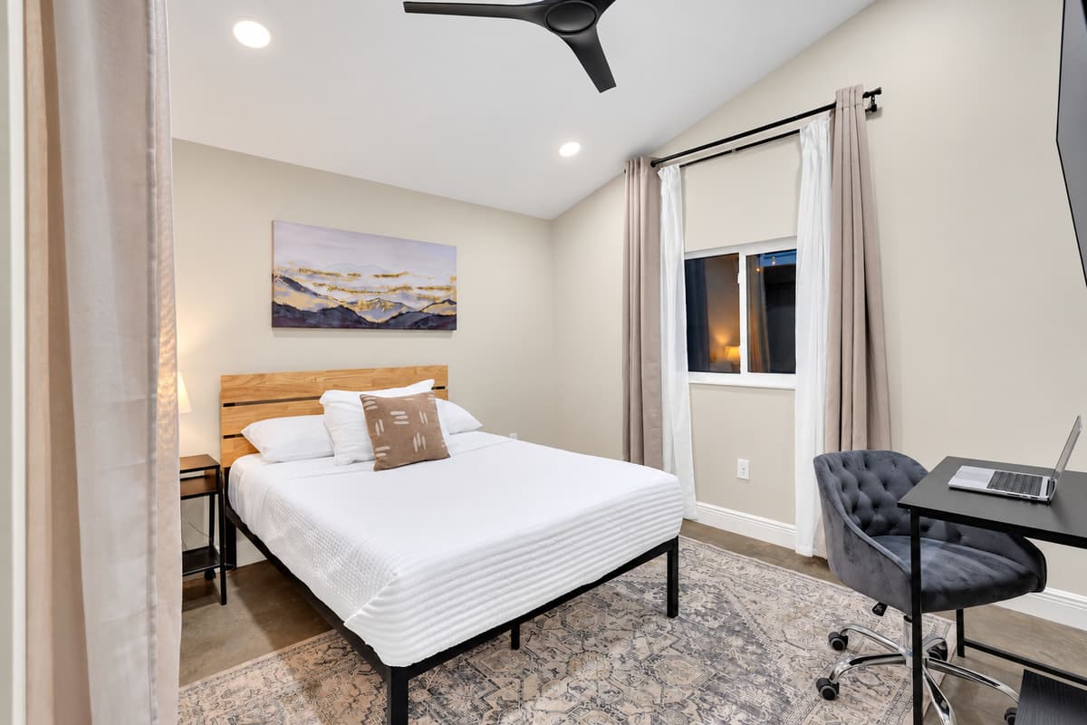 A bedroom with a desk, for the trip you can't fully leave. King-height comfort, a proper work chair and a window with morning light — take the call before nine, then be at the pool by ten.