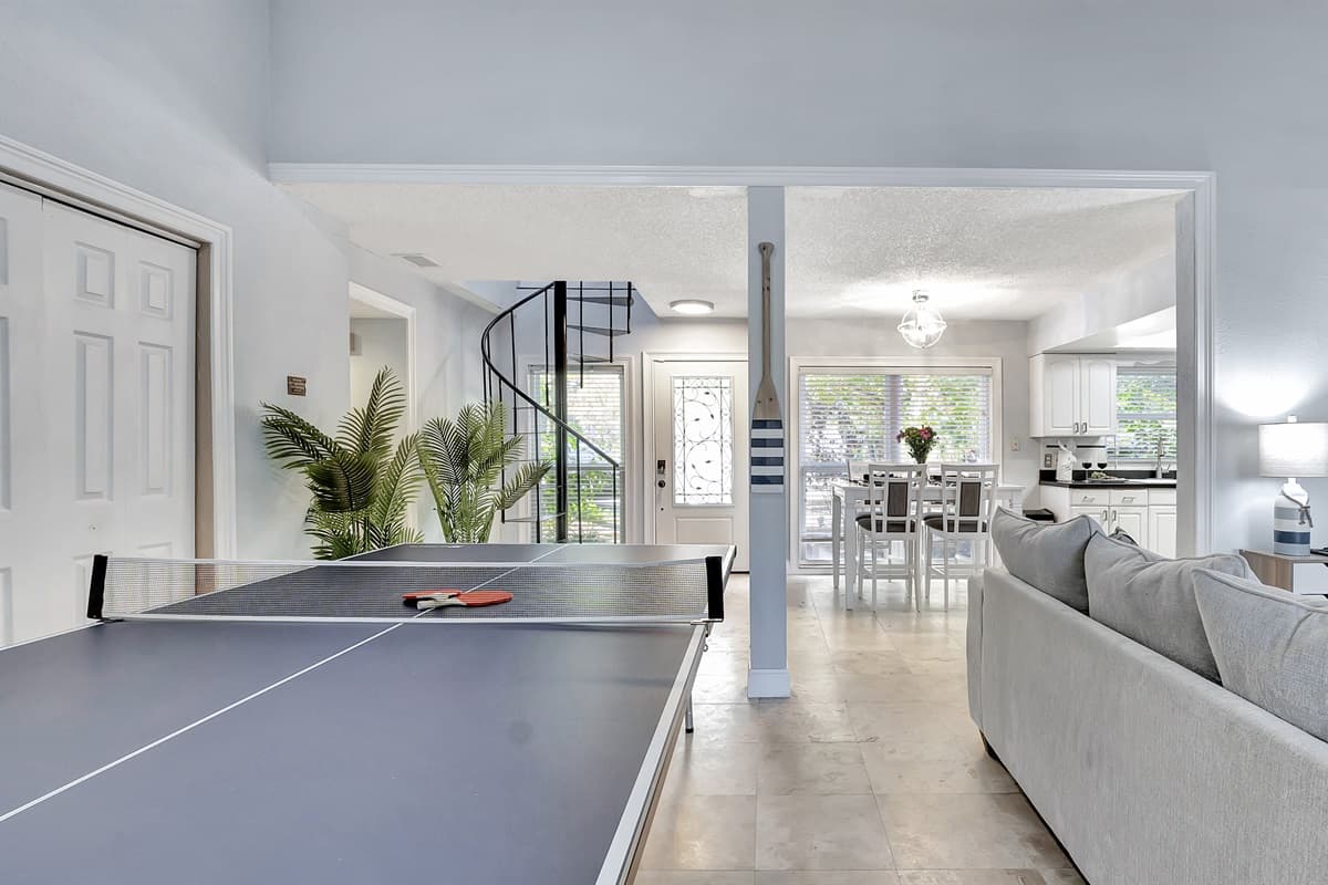 The ping pong table, strategically placed for easy access, adds a dynamic touch to your living space.