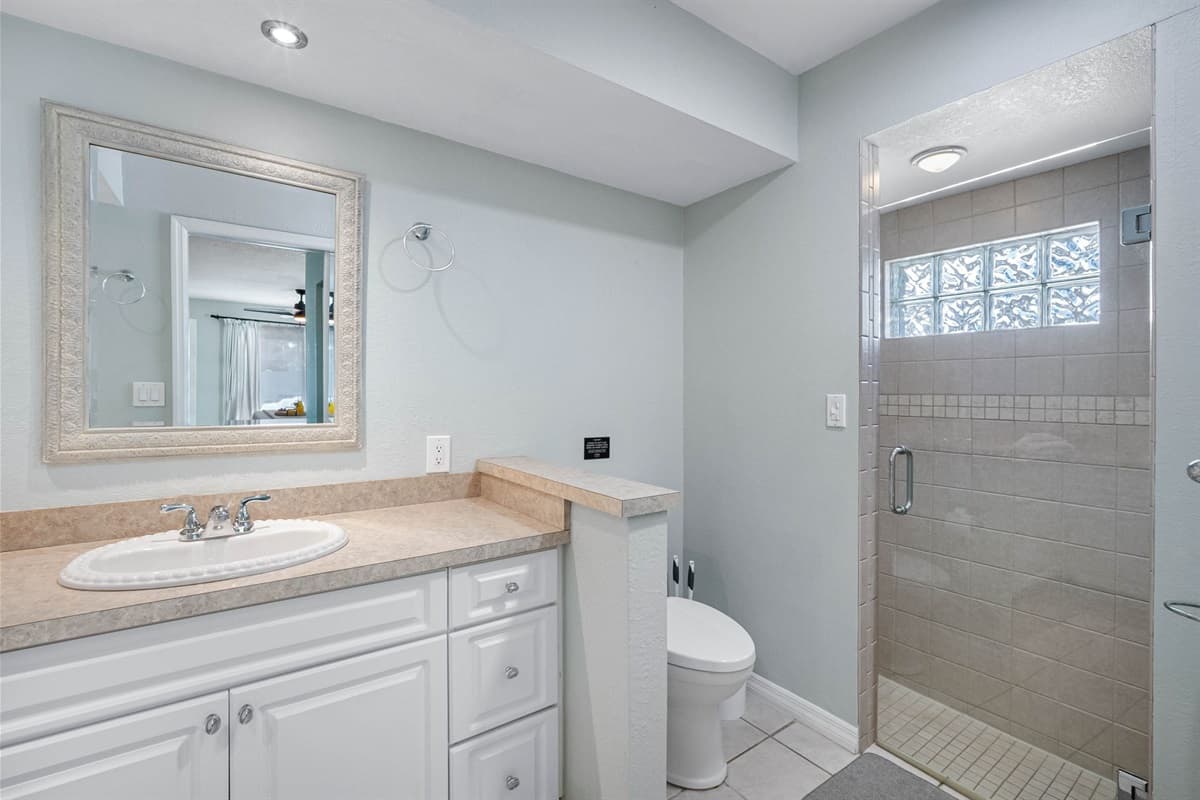 This bathroom combines style and practicality with twin sinks and a beautifully tiled shower.