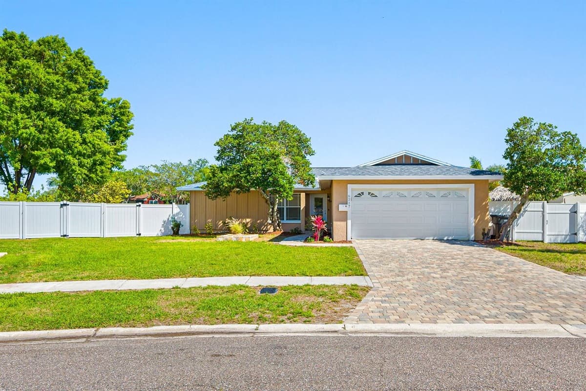 Beautiful front view of the house that has a wide driveway and a garage. Who doesn't love a view of green grass and beautiful trees around the house? If you like what you see, send us a message as soon as possible!
