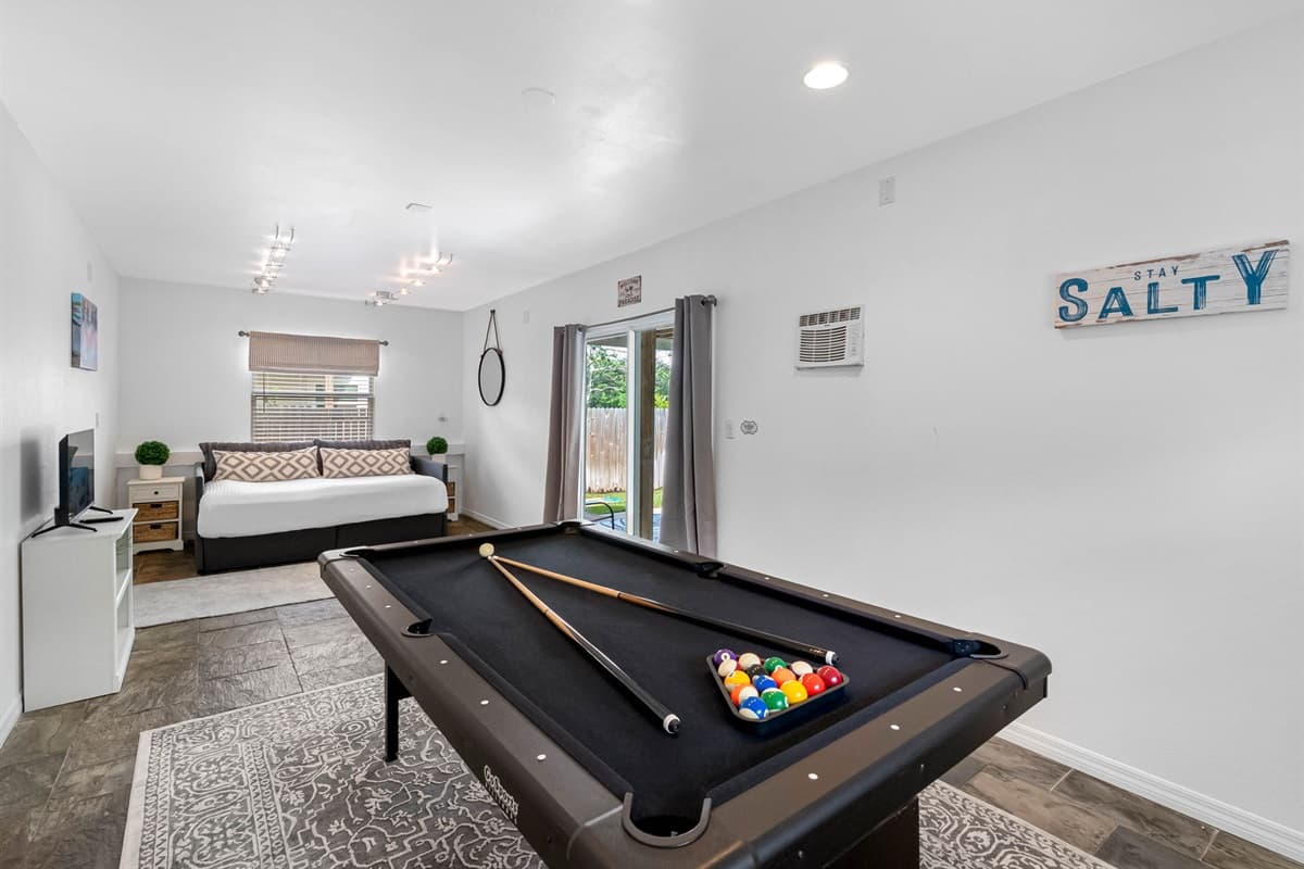 Multi-purpose space featuring a full bed and pool table for ultimate fun.