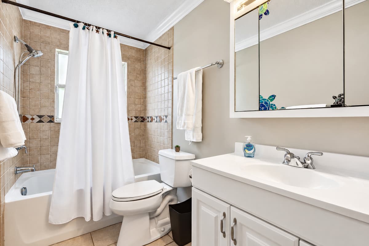 The tub and shower combination, with its sleek design and premium finishes, offers a haven for relaxation.