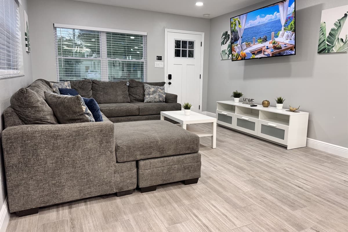 The decor in the living area is a blend of modern sophistication and cozy charm, featuring neutral tones, clean lines, and tasteful accents.