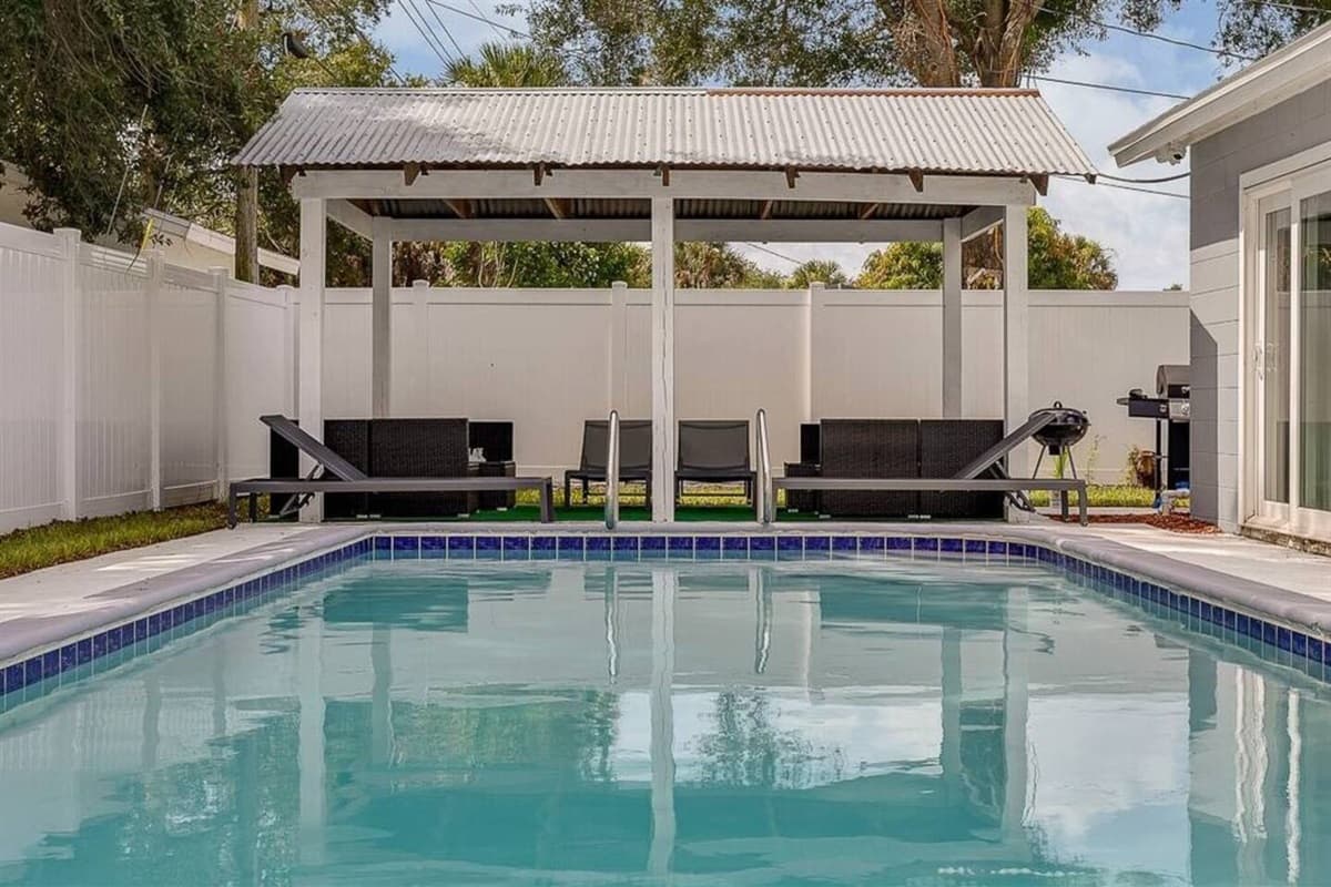 This is our amazing pool with a patio perfect for relaxation with family and friends on hot days in Florida. Our pool also has colored lights and is heated. We offer patio furniture for your convenience.