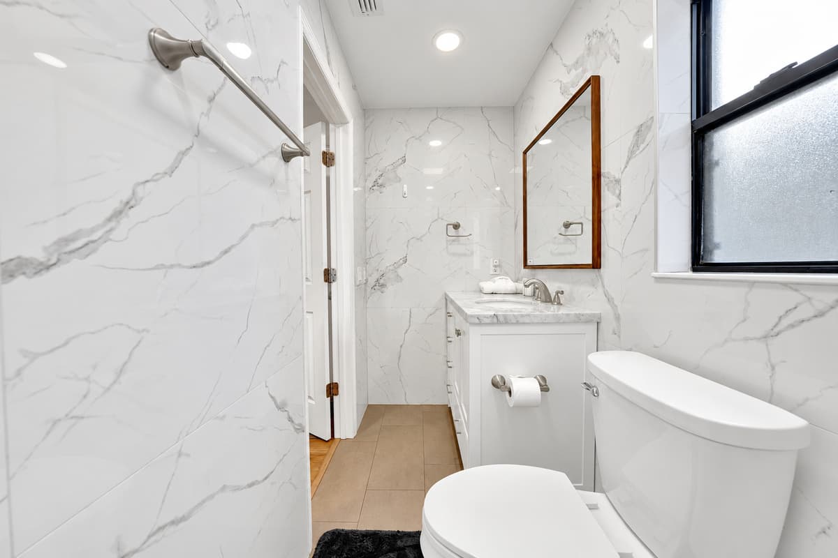 The second bathroom has a walk-in rain shower with no tub lip to step over — the one everyone quietly competes for after a long beach day. Shampoo, conditioner, body wash and a hair dryer are already here.