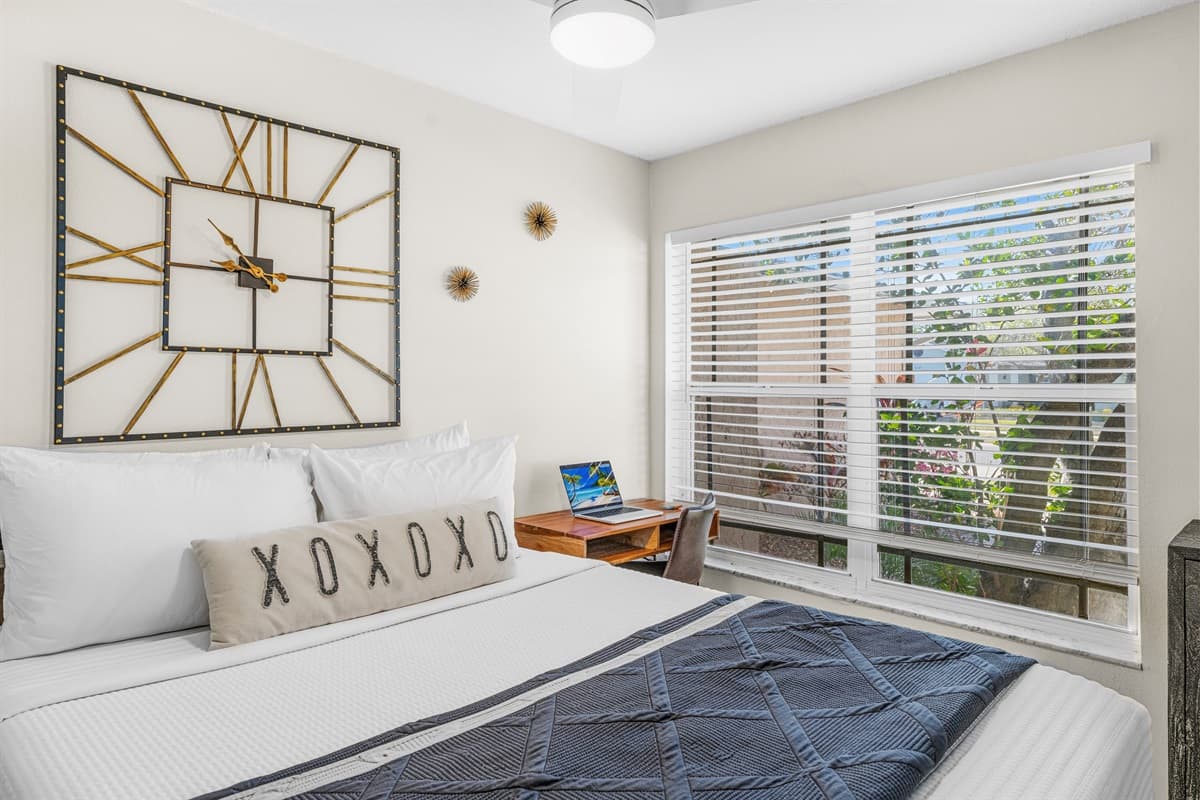 Relaxing queen bedroom featuring cozy décor and peaceful backyard views.
