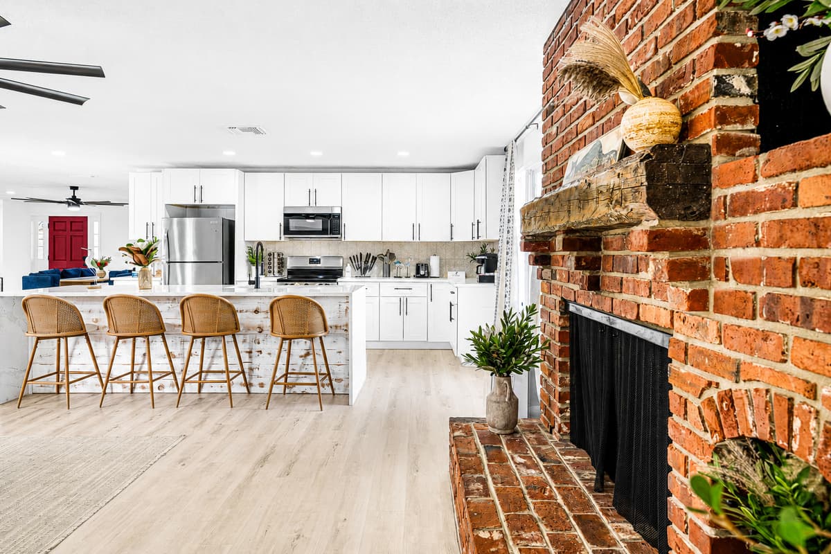 Exposed brick on one side, full kitchen on the other, four stools between them. The cook is never alone in here.