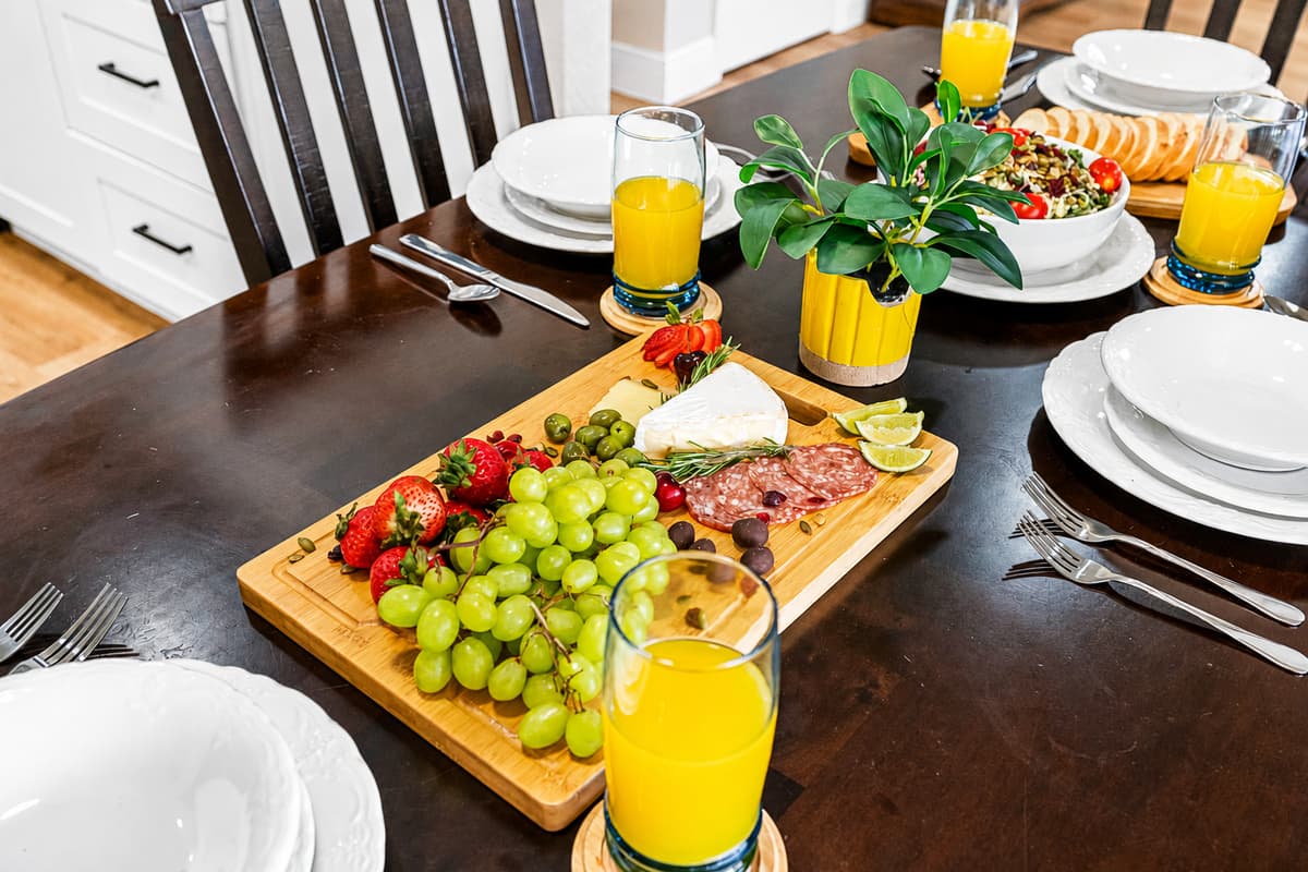The dark wood dining table comfortably seats four and is surrounded by padded high-back chairs that invite lingering meals and good conversation.