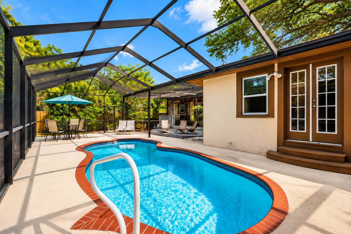 Scenic poolside view featuring outdoor seating, dining space, and a private resort-style atmosphere.