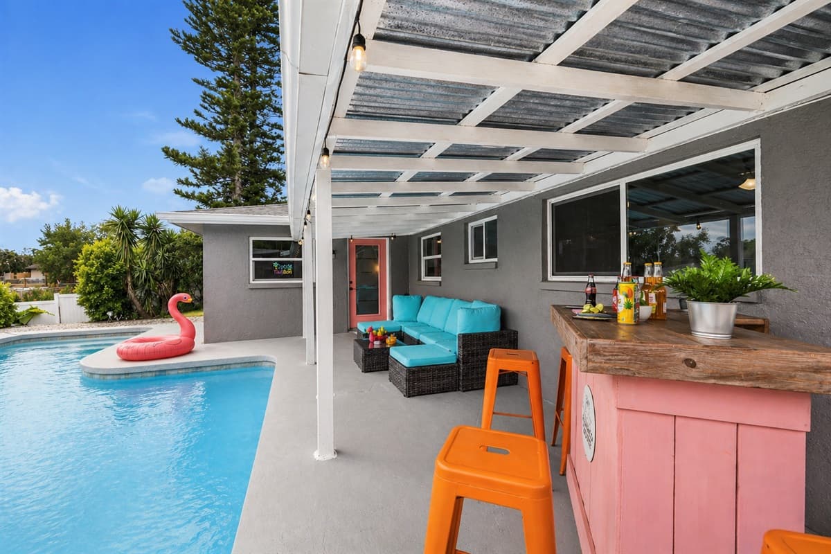 Seamless indoor-outdoor setup with bar, seating, and pool just steps away.