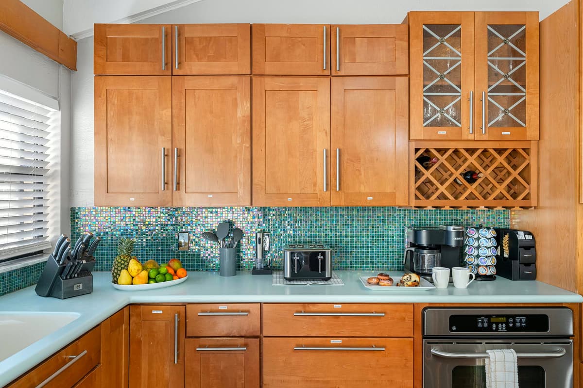 The colorful mosaic backsplash adds personality and a pop of charm to this inviting kitchen.
