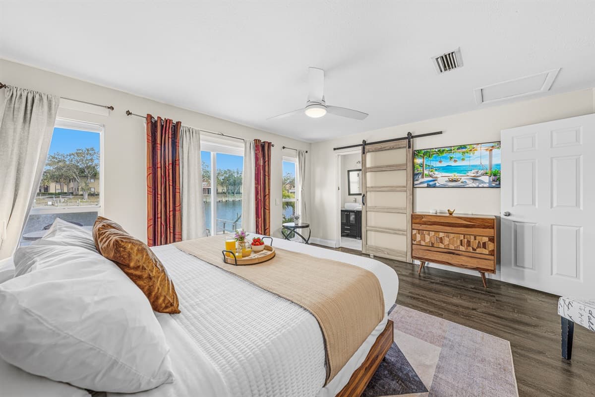 Relax in the oversized primary suite with Smart TV, king bed, and direct patio access.