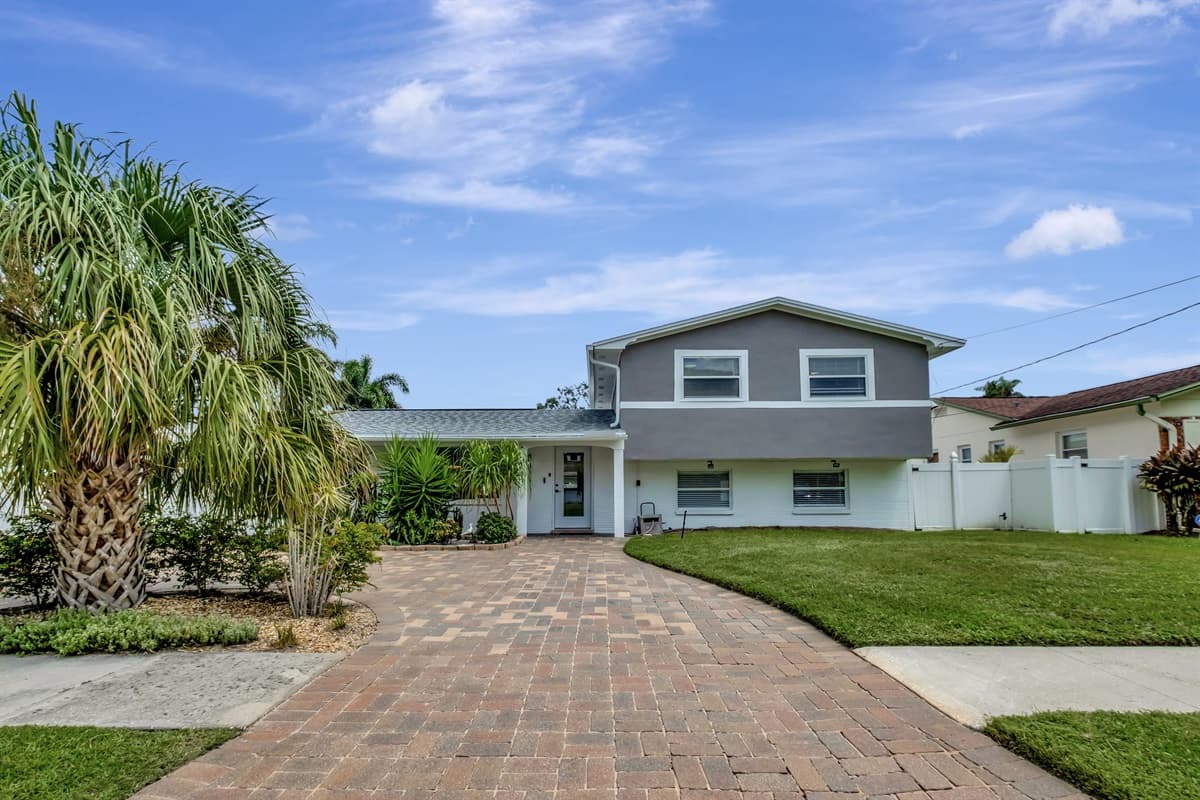 Stunning front view of the house showcasing the front yard and parking area that is equipped with CCTV cameras to ensure your safety during your stay. 