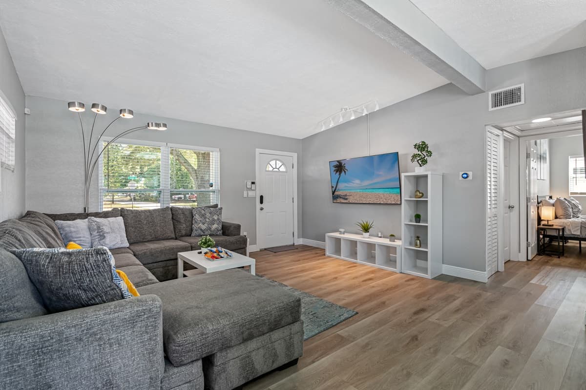 The living room is decorated with a plush grey carpet that adds texture and depth to the space while also providing a soft and cozy feel underfoot.