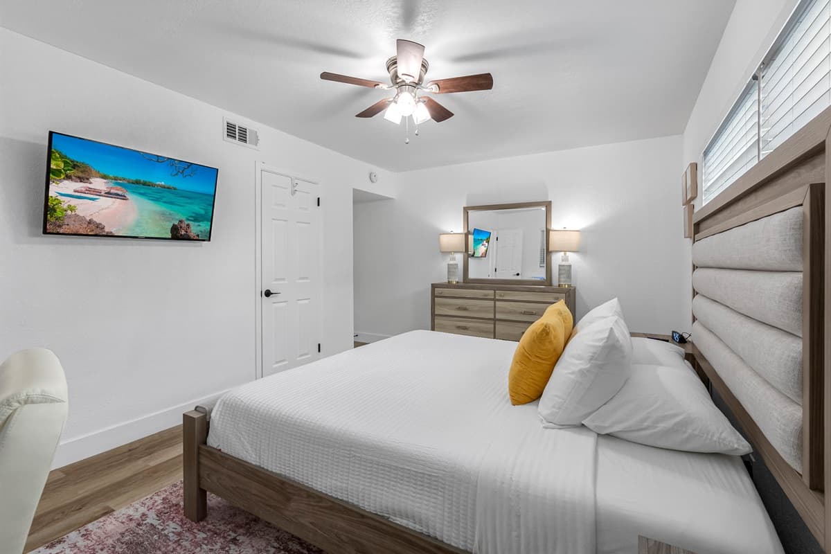 Bright, modern, and peaceful—this guest bedroom features a cozy queen bed, work desk, and plenty of natural light for a perfect stay.