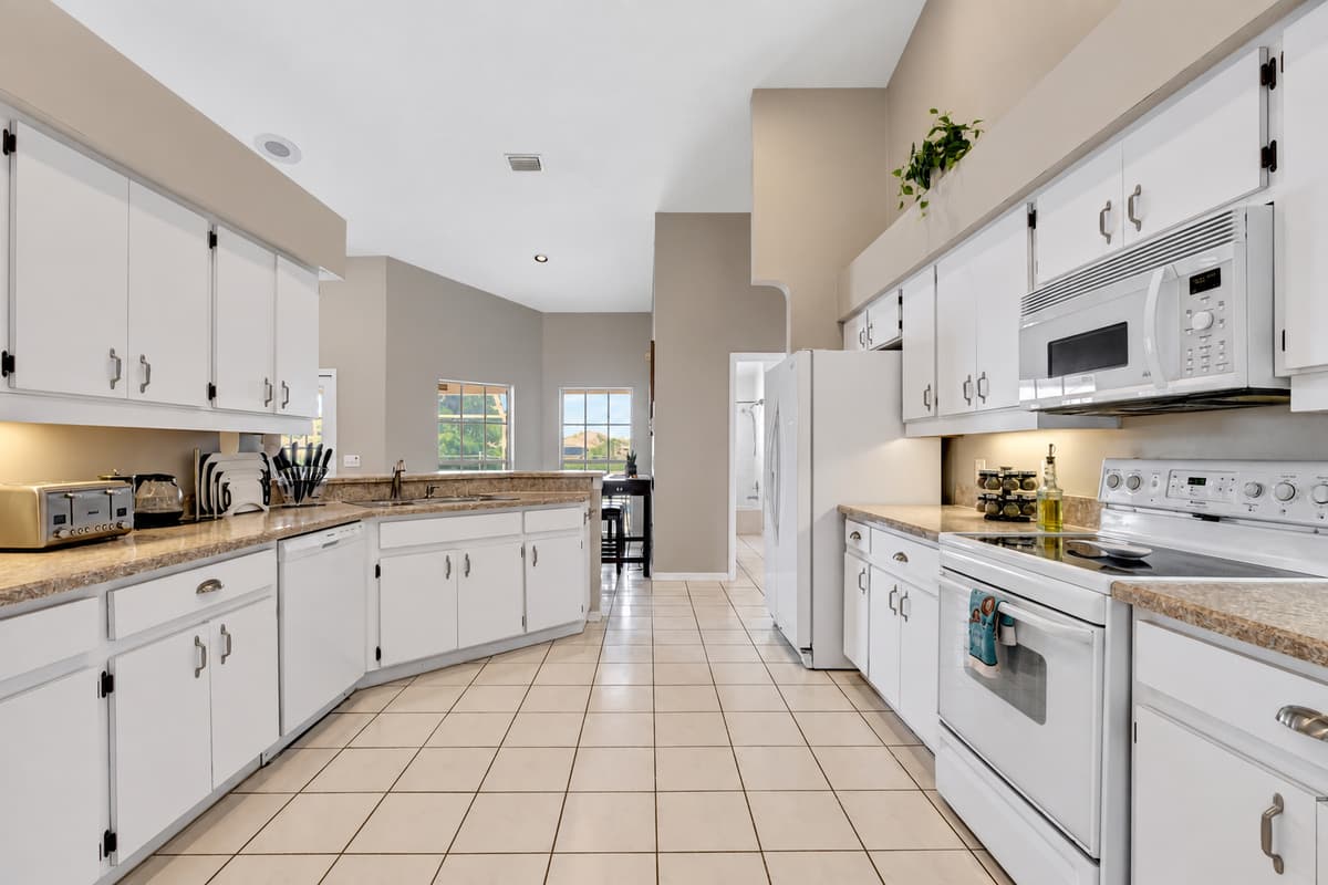 Sunlight pours through the expansive windows, infusing the kitchen with a natural radiance.