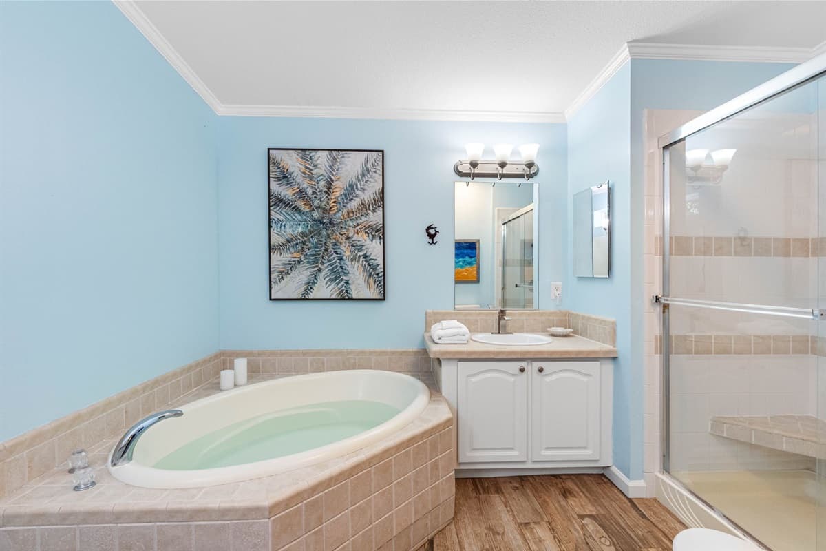 Unwind in the large soaking tub, beautifully framed by soft tilework, or refresh in the walk-in glass shower with built-in seating for added comfort.
